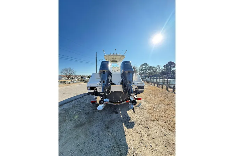 Slide: The Image of 2008 Robalo R240 Center Console boat with dual outboard motors, parked under a clear blue sky. - 58