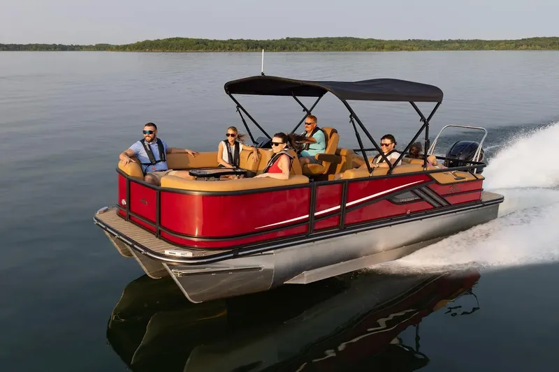Slide: The Image of 2026 SunCatcher Fusion 324SS pontoon boat cruising on a calm lake with passengers. - 17