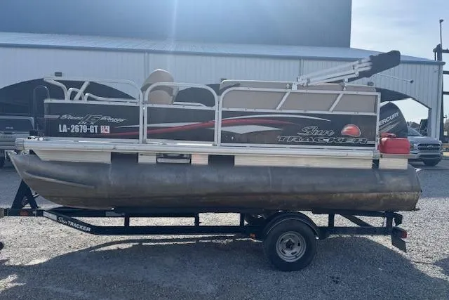 Slide: The Image of 2015 Sun Tracker Bass Buggy 16 DLX pontoon boat on trailer, parked outdoors. - 7