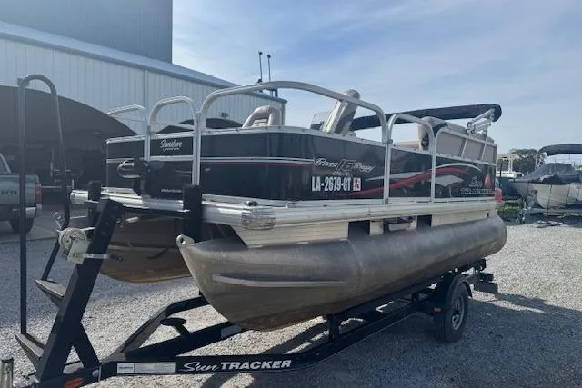Slide: The Image of 2015 Sun Tracker Bass Buggy 16 DLX pontoon boat on trailer, parked outdoors. - 8