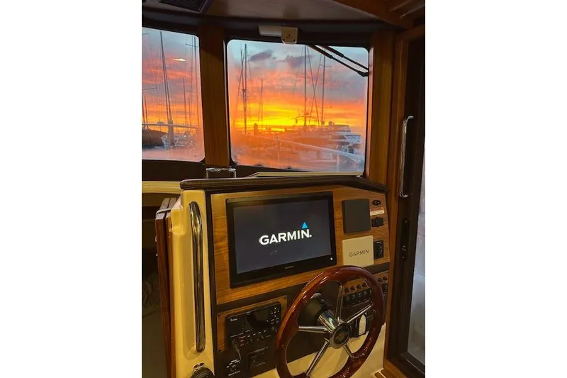 Slide: The Image of 2024 Ranger Tugs R-31 CB helm with Garmin display, sunset view through windows. - 17