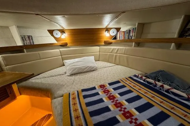 Slide: The Image of 2024 Ranger Tugs R-31 CB cabin interior with cozy bed and ambient lighting. - 18