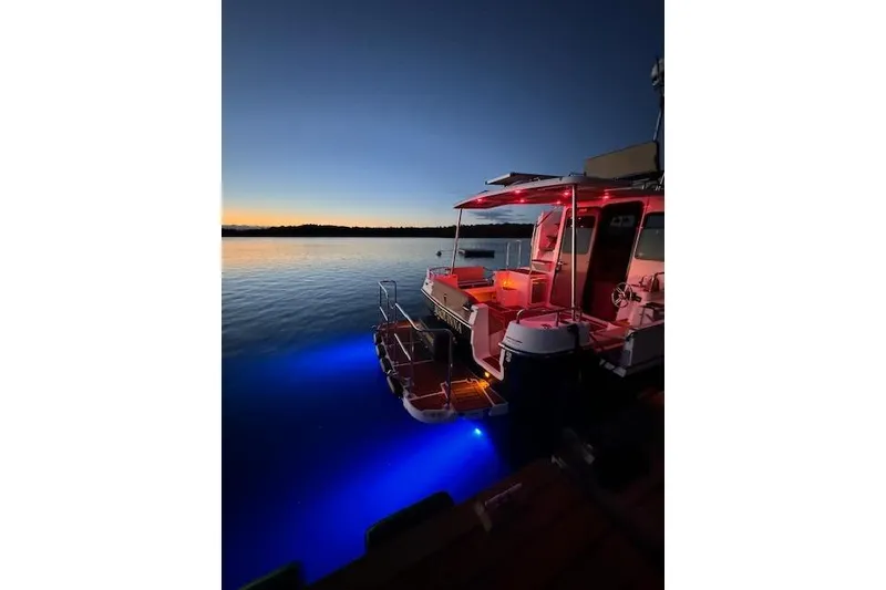Slide: The Image of 2024 Ranger Tugs R-31 CB boat illuminated at sunset on calm water. - 4