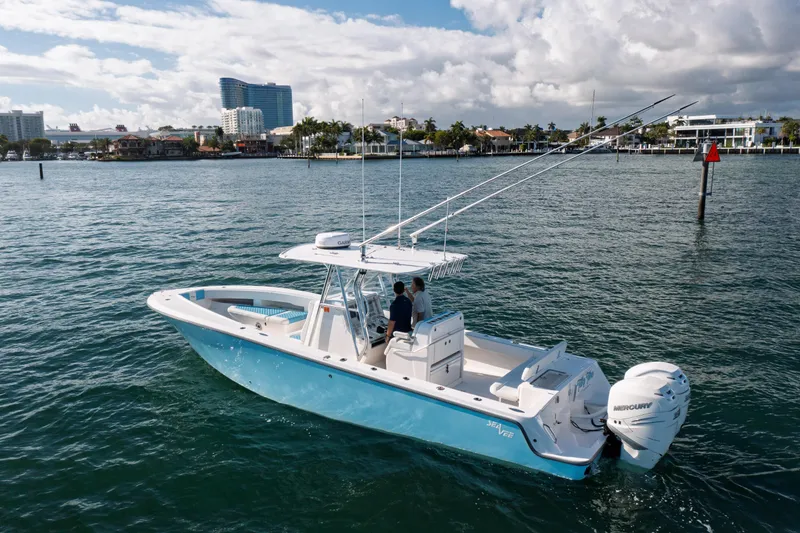 Slide: The Image of 2022 SeaVee 340Z boat cruising on a sunny day near coastal buildings. - 2