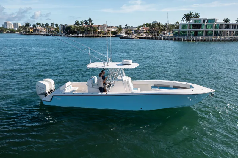 Slide: The Image of 2022 SeaVee 340Z boat cruising on a sunny day near waterfront homes. - 3