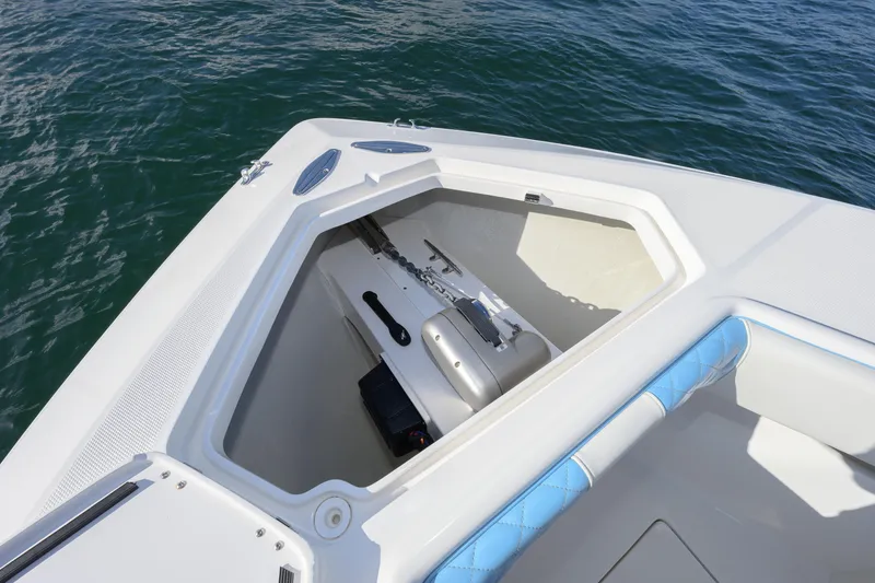 Slide: The Image of 2022 SeaVee 340Z boat anchor compartment with blue cushioned seating, on calm water. - 8