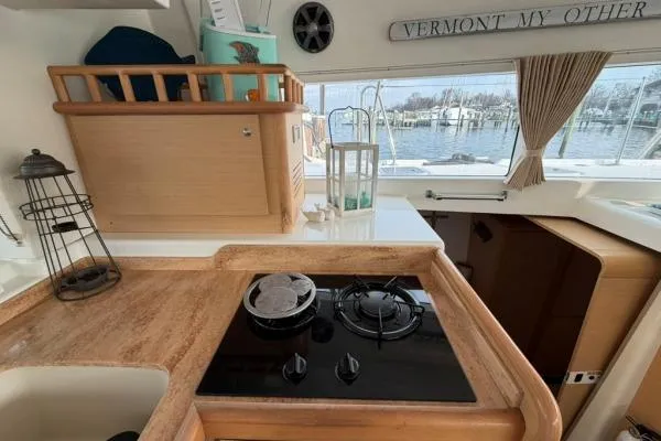 Slide: The Image of Interior of 2008 Lagoon 420 yacht kitchen with stove, sink, and marina view. - 14