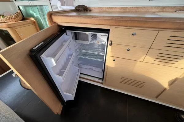 Slide: The Image of Open fridge in 2008 Lagoon 420 yacht kitchen with wooden cabinetry. - 15