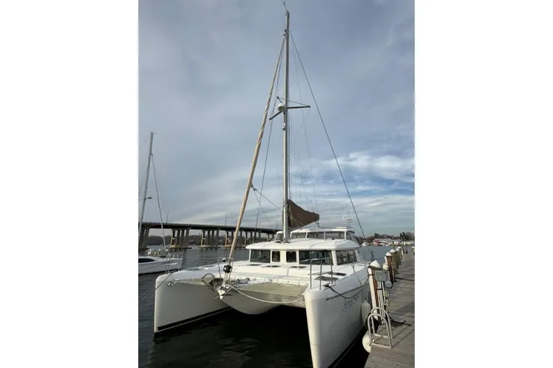 Slide: The Image of 2008 Lagoon 420 catamaran docked at marina under cloudy sky. - 2