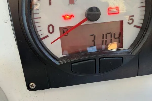 Slide: The Image of Close-up of a 2008 Lagoon 420 gauge displaying 3104 hours with warning lights. - 34