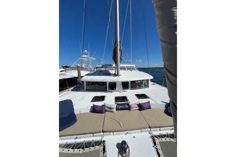 Slide: The Image of 2008 Lagoon 420 catamaran with sunbathing area, docked under clear blue sky. - 4