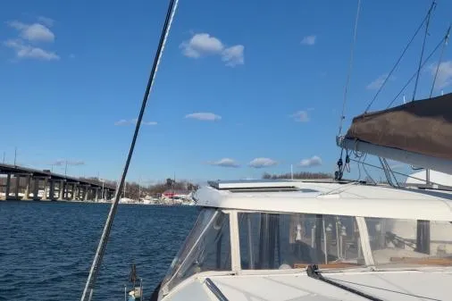 Slide: The Image of 2008 Lagoon 420 sailboat on water near a bridge under a clear blue sky. - 46