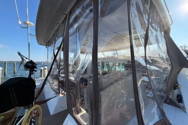 Slide: The Image of 2008 Lagoon 420 yacht with clear cockpit enclosure, docked at a marina. - 48