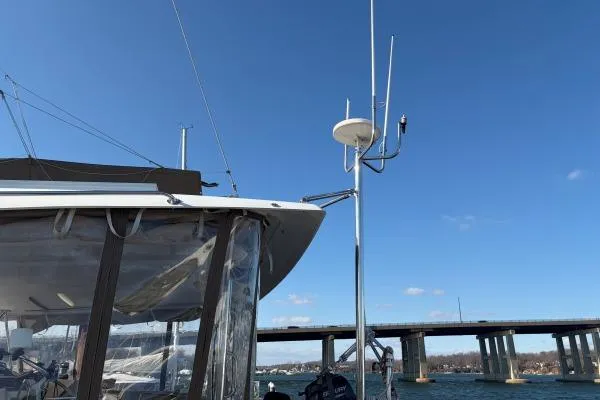 Slide: The Image of 2008 Lagoon 420 sailboat with antennas, bridge in background, clear blue sky. - 49