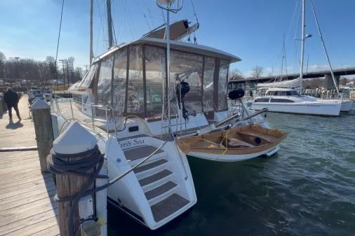 Slide: The Image of 2008 Lagoon 420 catamaran docked at marina, clear day, wooden dinghy attached. - 52
