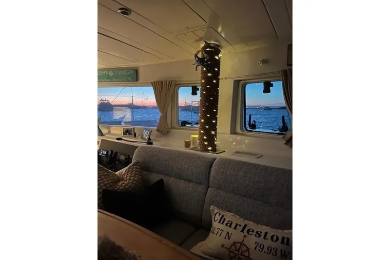 Slide: The Image of Interior of 2008 Lagoon 420 catamaran with cozy seating and ocean view at sunset. - 9