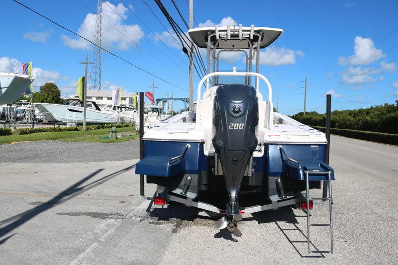 Slide: The Image of 2024 Robalo 226 Cayman boat with Yamaha 200 engine, parked outdoors under clear blue sky. - 4