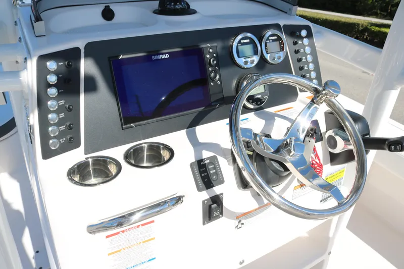 Slide: The Image of 2024 Robalo 226 Cayman boat dashboard with steering wheel and navigation controls. - 8