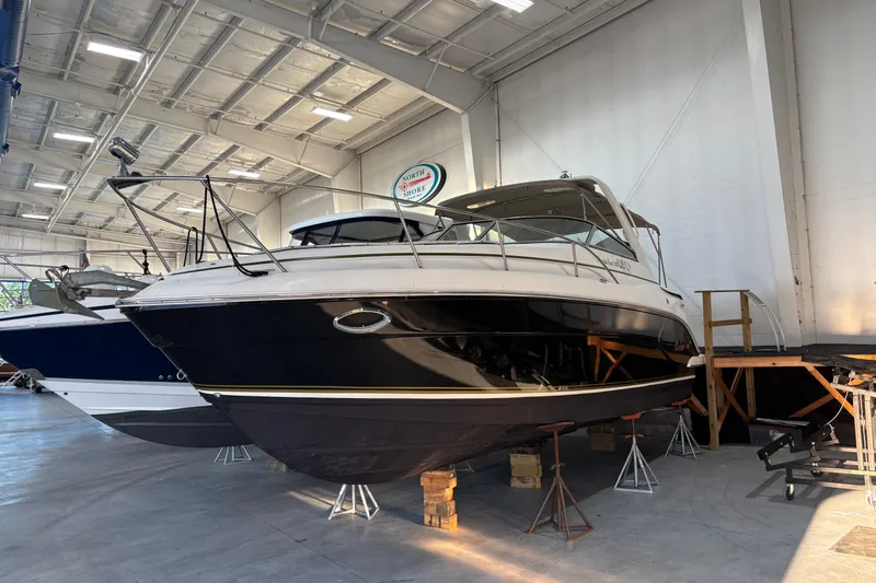 The Image of 2005 Rinker Fiesta Vee 300 docked at a marina under a clear sky. - 0