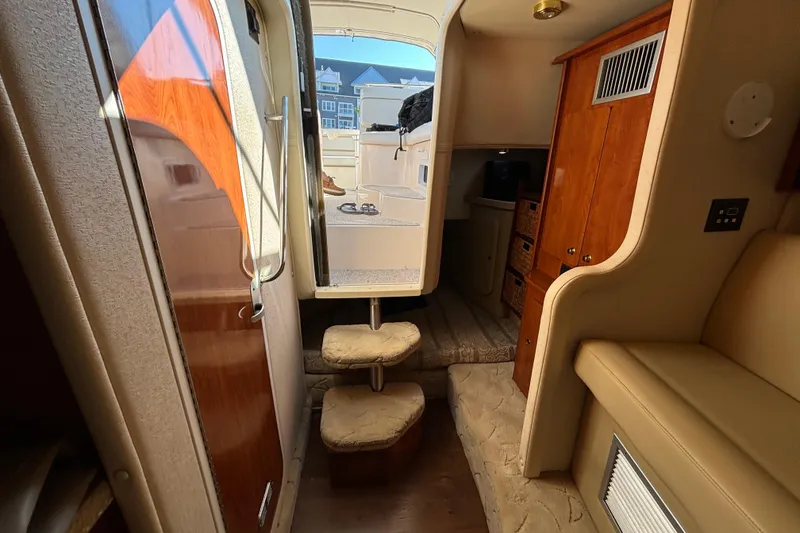 Slide: The Image of 2005 Rinker Fiesta Vee 300 interior with beige seating and wooden accents. - 13