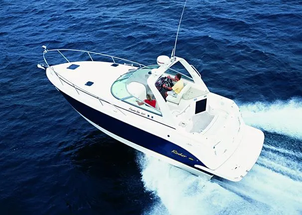 Slide: The Image of Interior of 2005 Rinker Fiesta Vee 300 boat, featuring cozy seating and wooden cabinetry. - 14