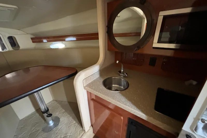 Slide: The Image of 2005 Rinker Fiesta Vee 300 boat docked in a marina, surrounded by other vessels. - 8