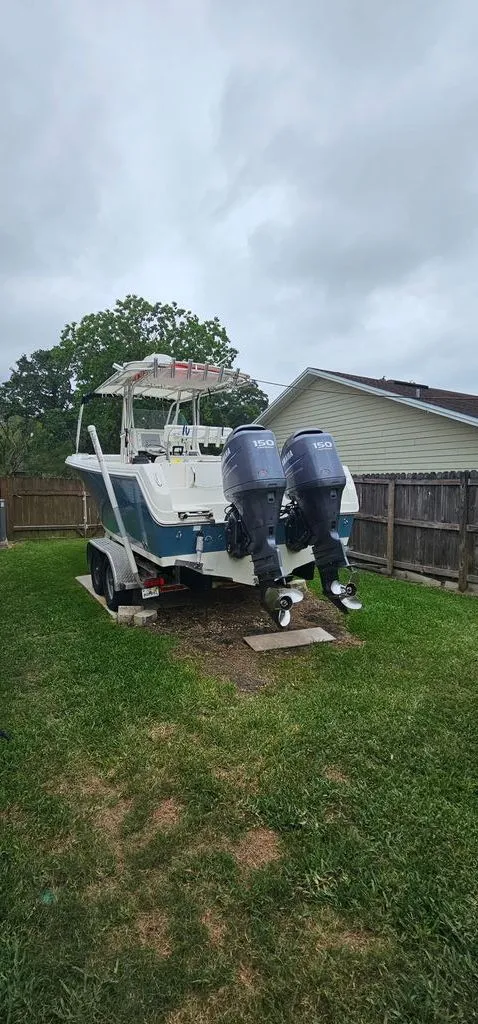Slide: The Image of 2008 Sailfish 2360 CC boat with dual outboard motors in a backyard. - 33