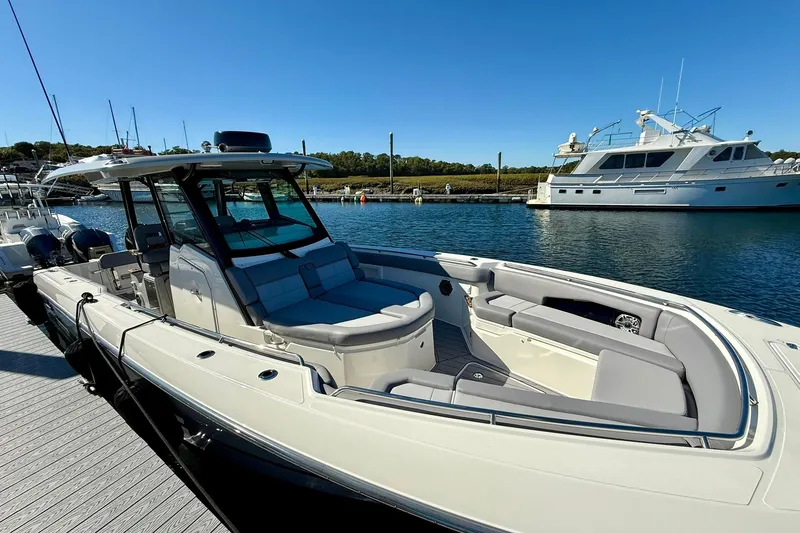 Slide: The Image of 2024 Boston Whaler 360 Outrage boat docked in a marina under clear blue skies. - 10