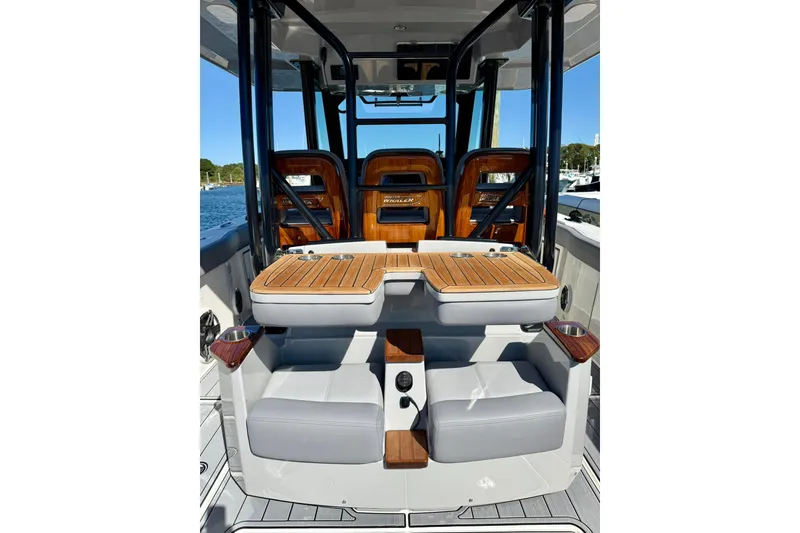 Slide: The Image of 2024 Boston Whaler 360 Outrage interior with luxurious seating and wooden accents. - 15