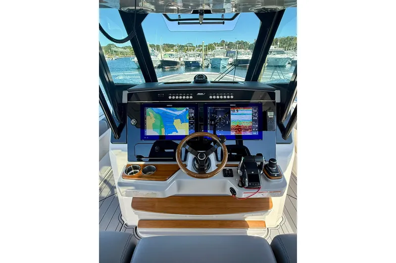 Slide: The Image of 2024 Boston Whaler 360 Outrage helm with advanced navigation displays and controls. - 17