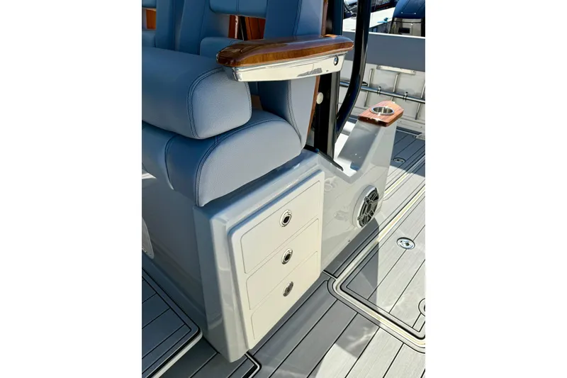 Slide: The Image of 2024 Boston Whaler 360 Outrage interior with seating, storage, and cup holders. - 22