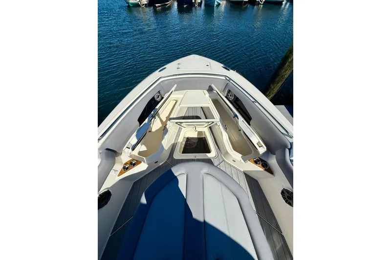 Slide: The Image of 2024 Boston Whaler 360 Outrage boat interior with seating and storage, docked on water. - 29