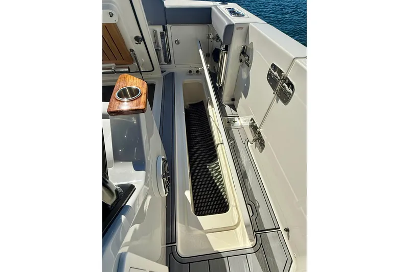 Slide: The Image of 2024 Boston Whaler 360 Outrage boat deck with storage compartment and cup holder. - 38
