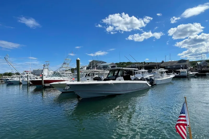 Slide: The Image of 2024 Boston Whaler 360 Outrage docked in a marina under a clear blue sky. - 4