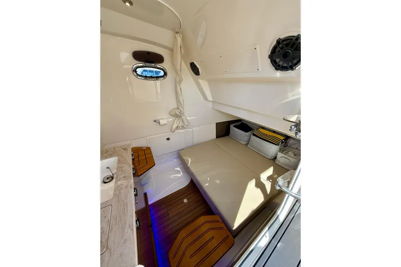Slide: The Image of 2024 Boston Whaler 360 Outrage cabin interior with seating and storage. - 44