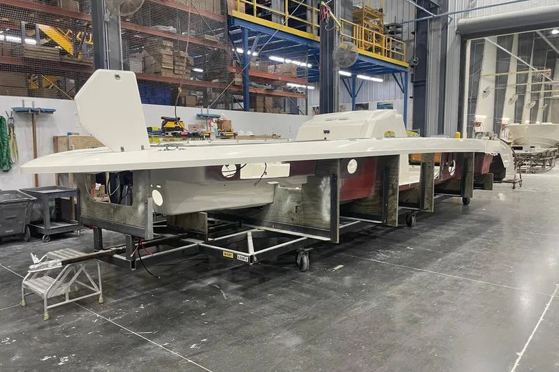 Slide: The Image of 2024 Boston Whaler 360 Outrage boat under construction in a factory setting. - 48