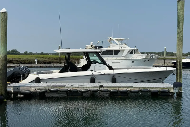 Slide: The Image of 2024 Boston Whaler 360 Outrage docked at marina, side view. - 5
