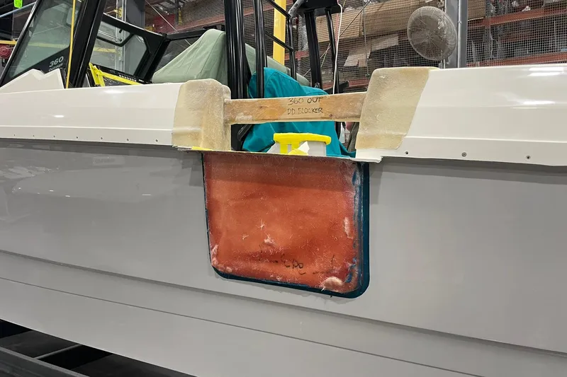 Slide: The Image of 2024 Boston Whaler 360 Outrage boat under construction in a workshop. - 55