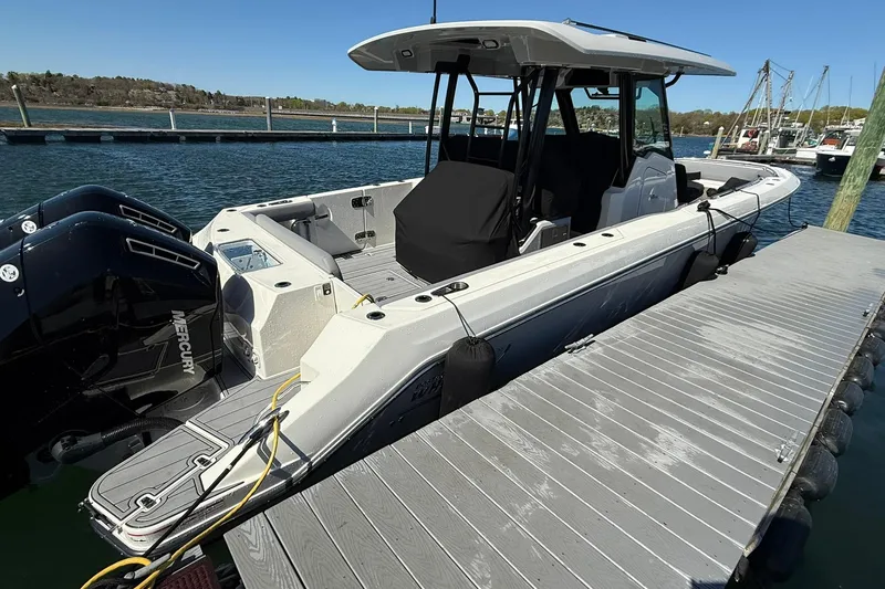 Slide: The Image of 2024 Boston Whaler 360 Outrage docked, featuring sleek design and powerful Mercury engines. - 6