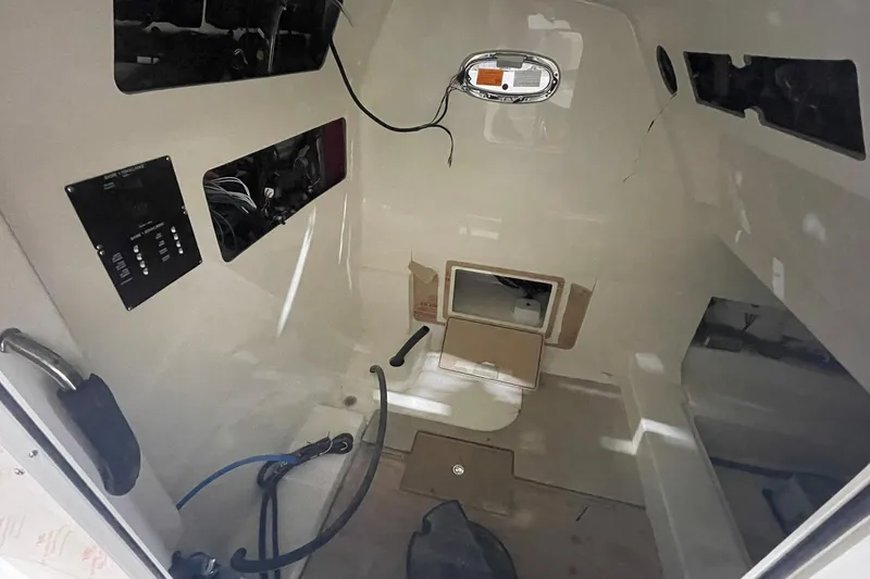 Slide: The Image of Interior view of 2024 Boston Whaler 360 Outrage boat cabin, featuring control panels and storage. - 60