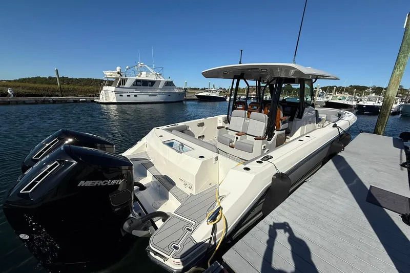 Slide: The Image of 2024 Boston Whaler 360 Outrage docked, featuring dual Mercury engines, in a marina setting. - 7
