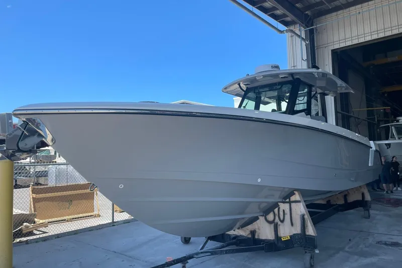 Slide: The Image of 2024 Boston Whaler 360 Outrage boat in a marina, side view. - 76