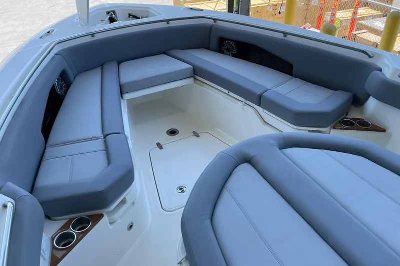 Slide: The Image of 2024 Boston Whaler 360 Outrage boat interior with gray cushioned seating and cup holders. - 79