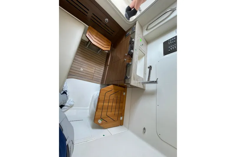 Slide: The Image of 2024 Boston Whaler 360 Outrage interior with wooden accents and modern amenities. - 81