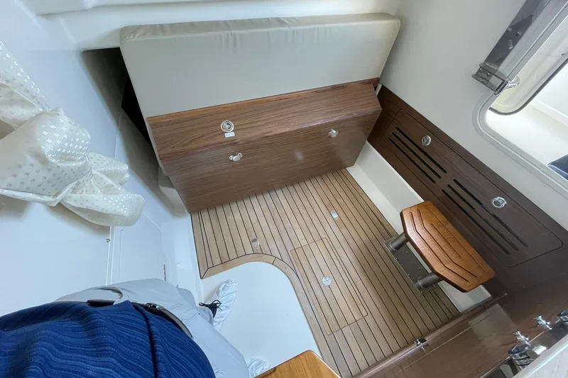 Slide: The Image of 2024 Boston Whaler 360 Outrage cabin interior with wood flooring and seating. - 82