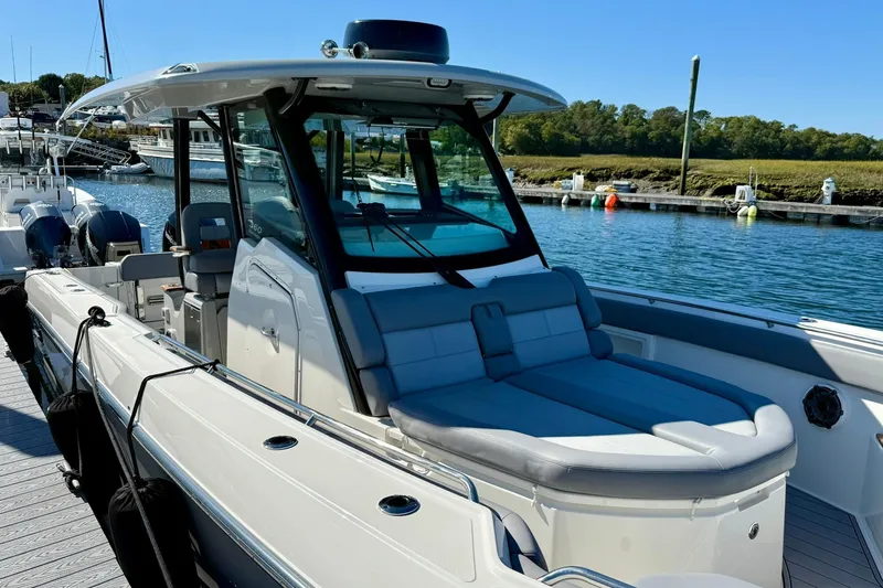 Slide: The Image of 2024 Boston Whaler 360 Outrage boat docked, featuring sleek design and spacious seating. - 9