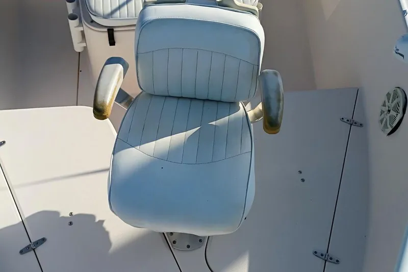 Slide: The Image of Captain's chair on 2004 Grady-White Escape 209 boat, featuring white upholstery and armrests. - 13