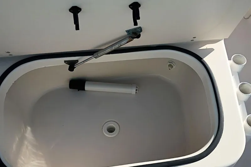 Slide: The Image of Livewell compartment in a 2004 Grady-White Escape 209 boat, featuring rod holders. - 15