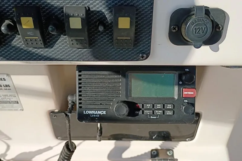 Slide: The Image of Control panel of a 2004 Grady-White Escape 209 with Lowrance Link-8 radio and switches. - 24