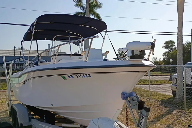 Slide: The Image of 2004 Grady-White Escape 209 boat on trailer with canopy, parked outdoors. - 28